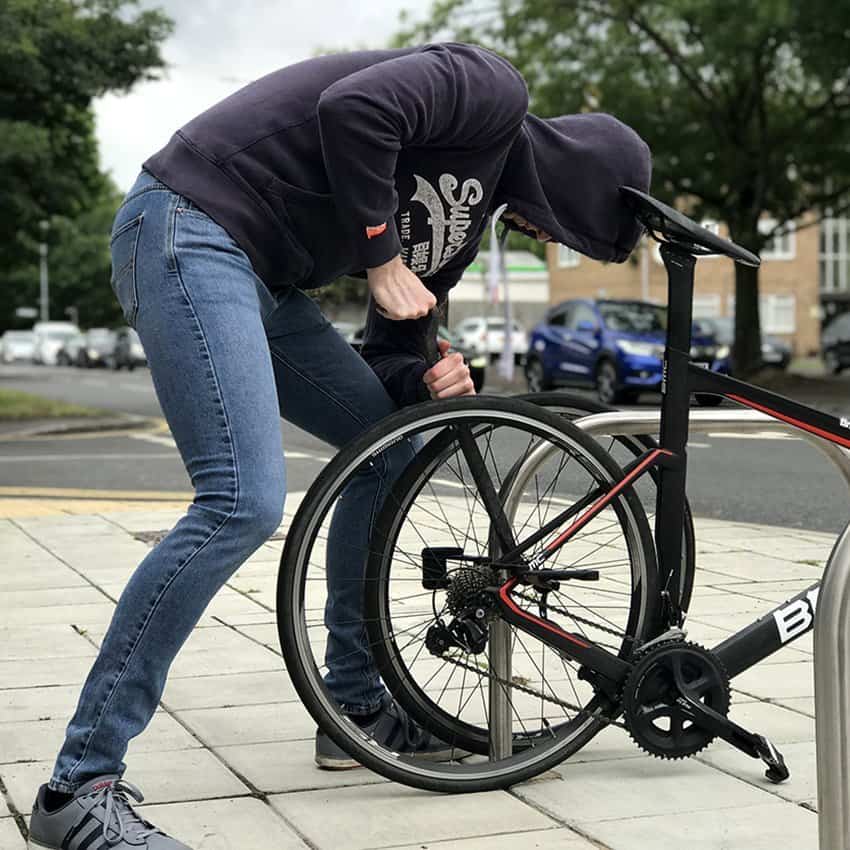 Thief stealing bike with crowbar